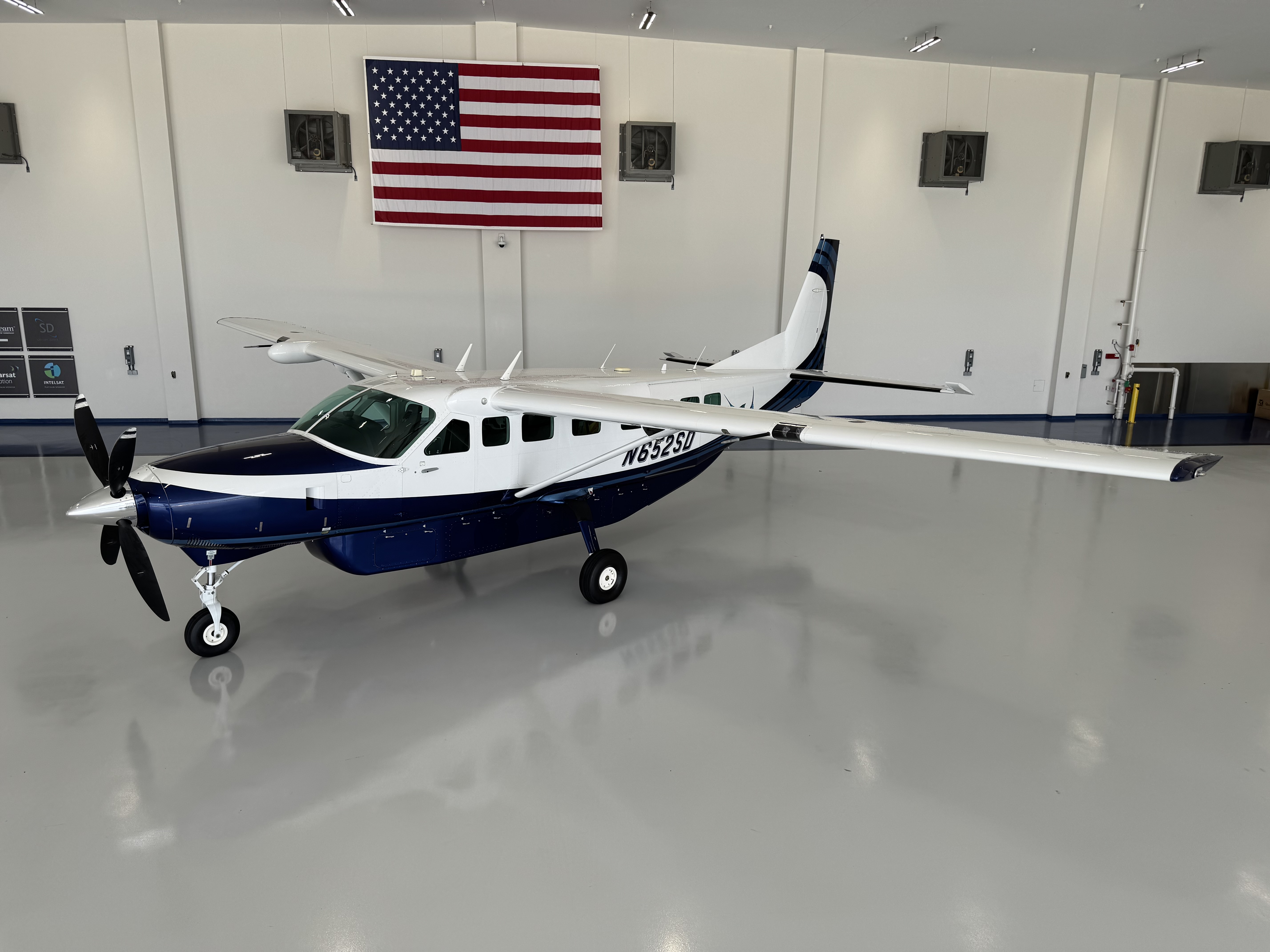 Blue and white Cessna Caravan inside the hangar