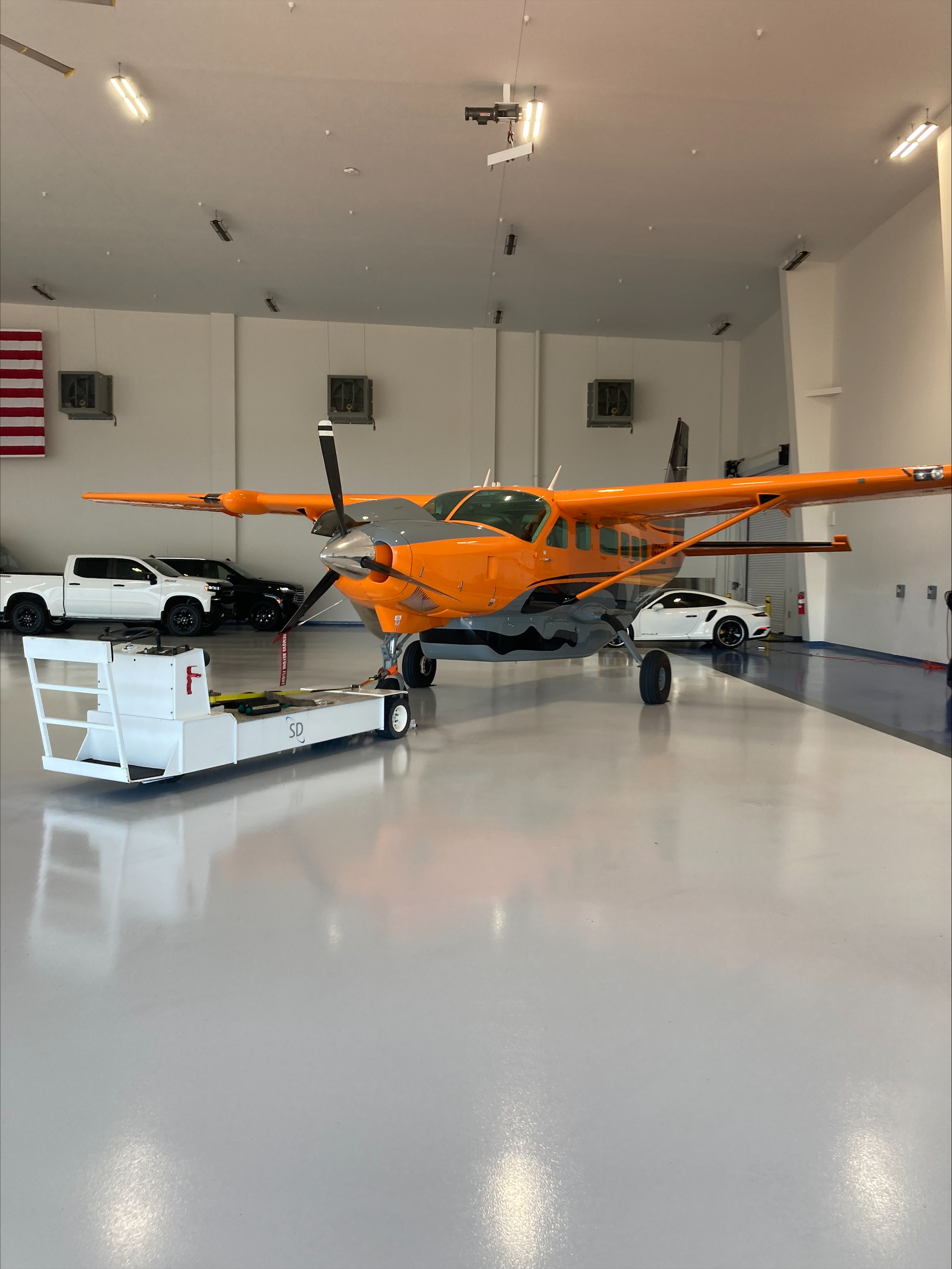 Orange Cessna Caravan parked inside the hangar