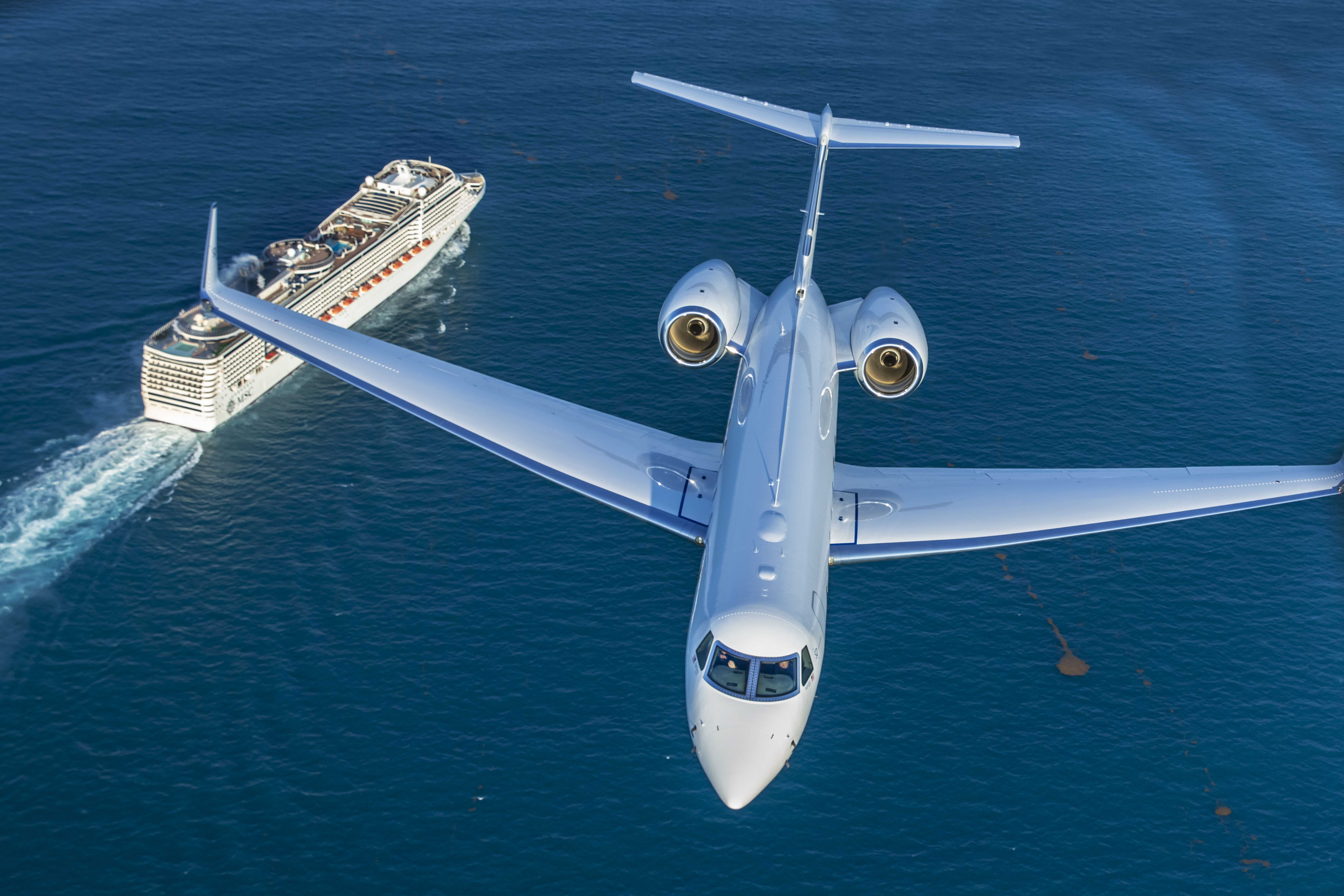 Gulfstream G550 flying over a cruise ship