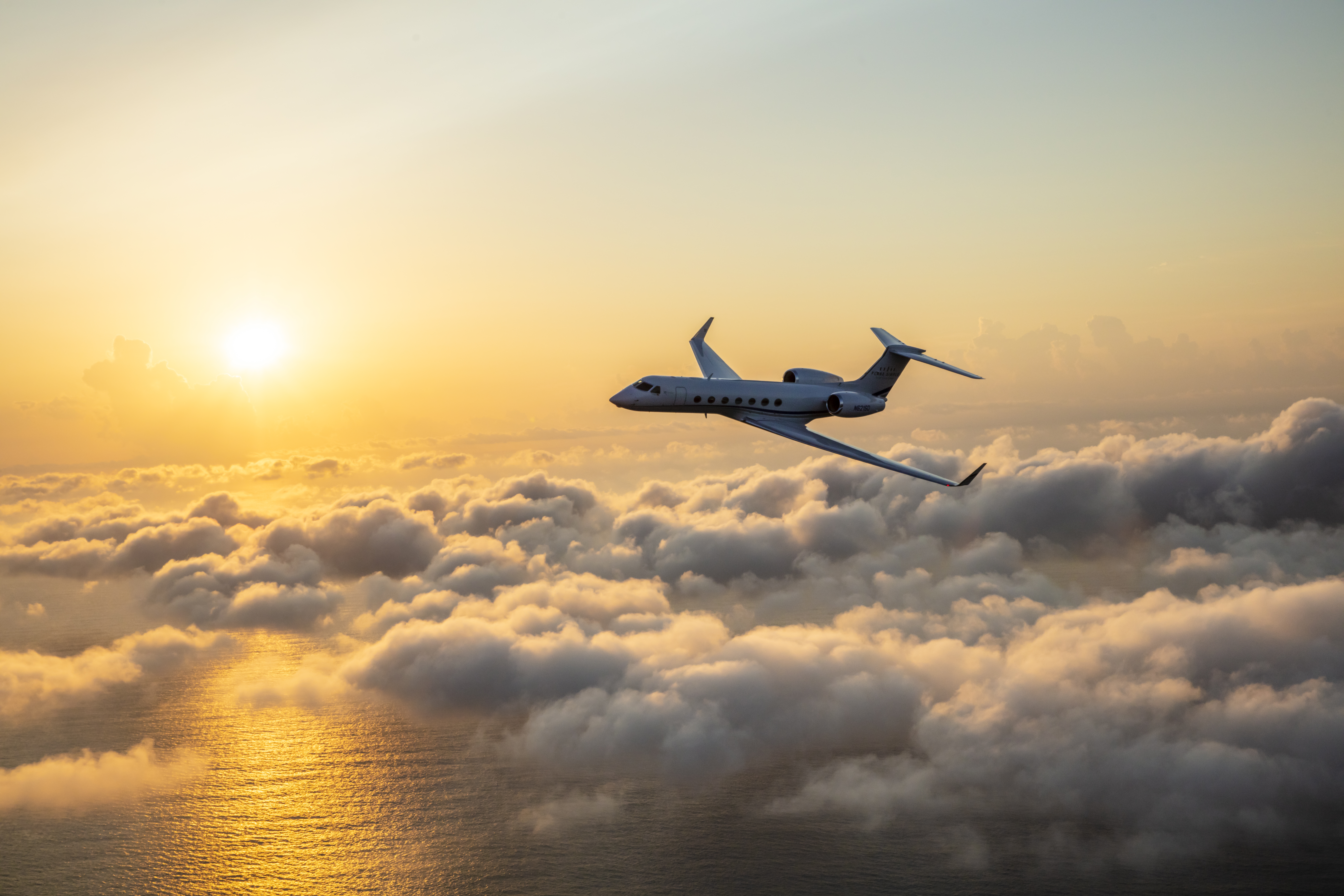 Gulfstream G550 flying through golden hour clouds
